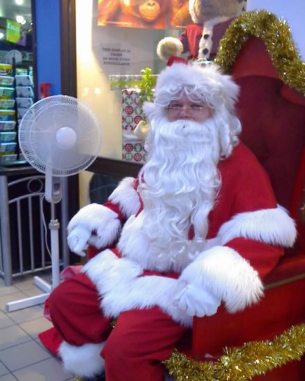 Santa sitting next to a fan