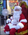 Santa sitting next to a fan